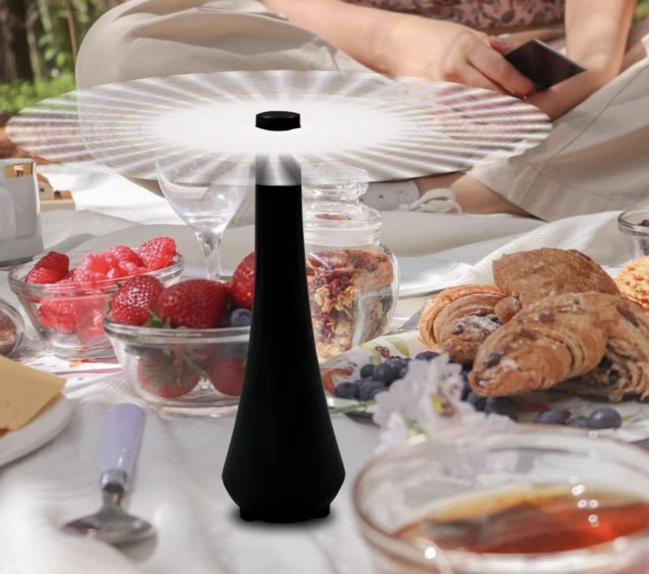 Ventilateur anti-mouches posé sur une table de petit-déjeuner en extérieur