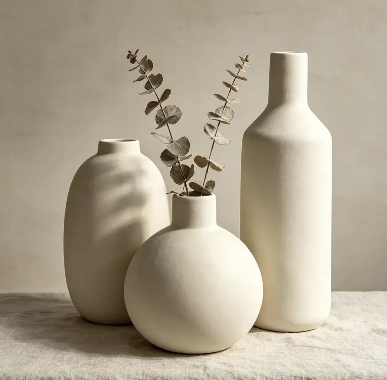 Trio de vases en porcelaine non émaillée sur un tissu de lin naturel