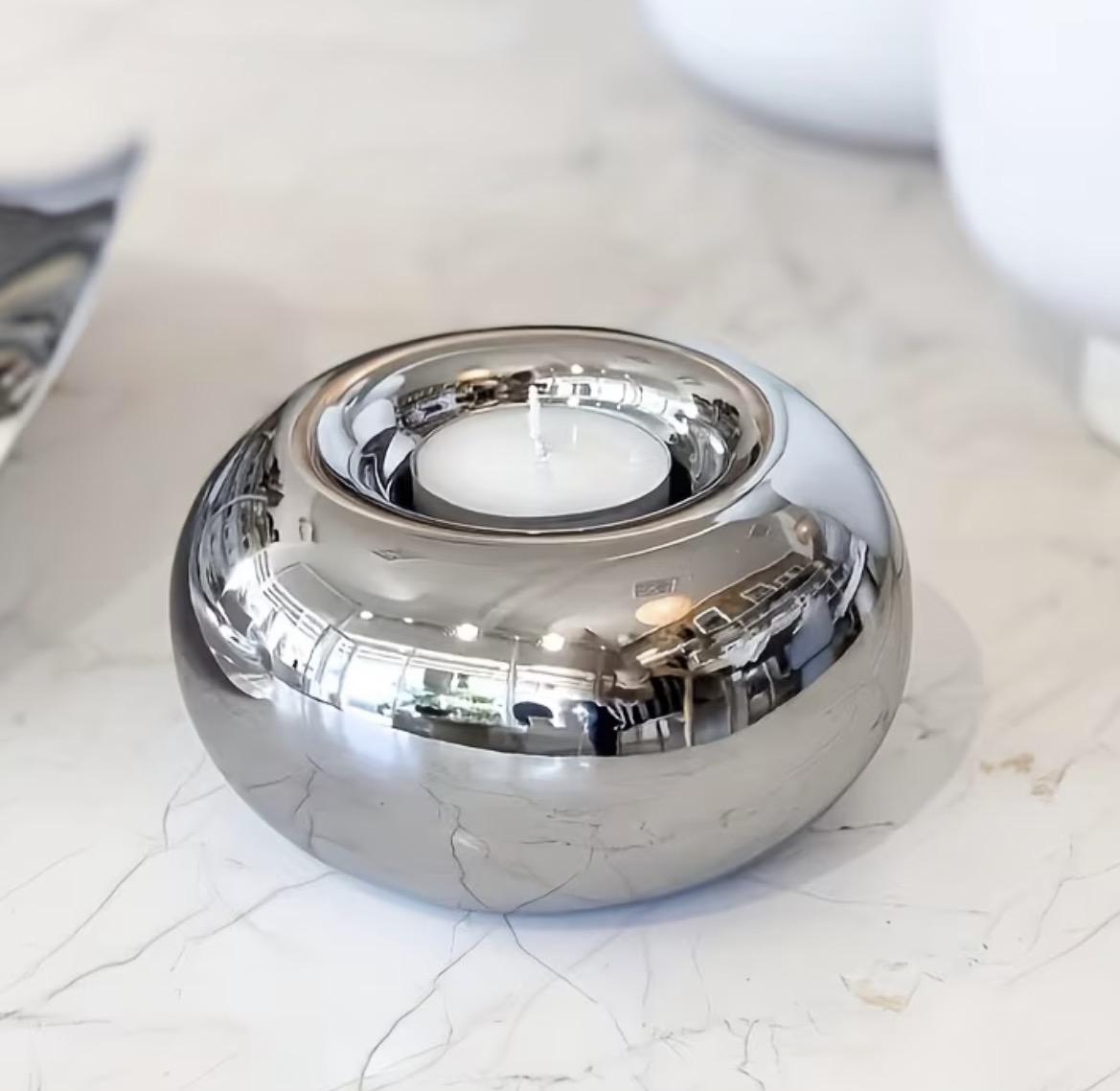 Bougeoir en céramique finition argentée avec une bougie chauffe-plat, sur un plan en marbre